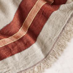 an orange and white striped blanket laying on top of a table