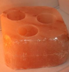 a piece of orange soap sitting on top of a white surface