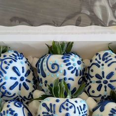 blue and white chocolate covered strawberries in a box