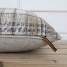 a close up of a pillow on a wooden floor with a key in the middle