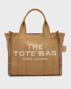 "Find MARC JACOBS The Tote Bag on Editorialist. This Marc Jacobs tote bag is crafted from canvas with an embroidered logo. It features flat top handles and a detachable, adjustable web shoulder strap. The bag has a zip top closure and measures approximately 16.3\"H x 11.8\"W x 5.5\"D." Beige Top Handle Bag With Embroidered Logo, Top Handle Bag With Embroidered Logo, Everyday Top Handle Bag With Embroidered Logo, Beige Shoulder Bag With Embroidered Logo And Double Handle, Beige Shoulder Bag With Embroidered Logo For Everyday Use, Beige Tote Bag With Embroidered Logo, Brown Rectangular Bag With Embroidered Logo, Brown Travel Bag With Embroidered Logo, Beige Bags With Embroidered Logo For Daily Use