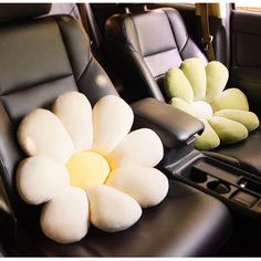 two black leather seats with white flowers on the front and back seat, one has a yellow center flower