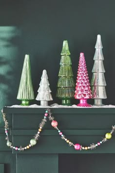 christmas trees are lined up on the mantle