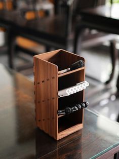 a wooden box with two wine bottles in it sitting on top of a glass table