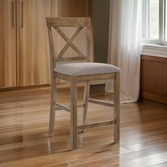 a wooden chair sitting in front of a window on top of a hard wood floor