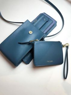 two blue purses sitting next to each other on top of a white countertop