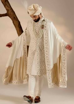 Featuring our infamous Kashmiri jamawar embroidered sherwani in dirty ivory color with floral design details. The piece is then highlighted with dabka and zari. Paired with a matching hand-embroidered stole and safa. Sherwani Groom Wedding, White Sherwani, Indian Wedding Clothes For Men, Drape Sarees, Ridhi Mehra, Embroidered Sherwani, Indian Groom Wear, Draped Saree, Sherwani Groom