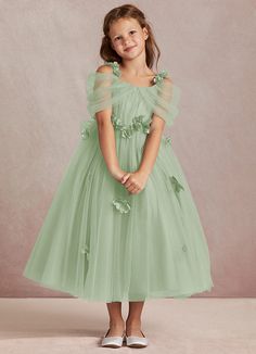 Shaylee is an enchanting A-line flower girl dress that is crafted from delicate tulle. She features intricately handmade 3D flower embellishments. Off-shoulder sleeves offer a touch of whimsy that is complimented with a tulle bow back. The flowers cascade gracefully down the tulle skirt that flows with every step. Green Ball Dresses, Off The Shoulder Tulle Dress, Sage Green Flower Girl Dress, Sage Flower Girl Dress, Lavender Flower Girl Dress, Pastel Green Dress, Green Flower Girl Dresses, Sage Green Bridesmaid Dress, Sage Green Dress