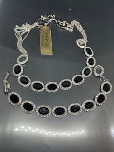 This exquisite jewelry set from Monet is a stunning addition to any collection. The set includes a beautiful silver tone chain necklace and bracelet adorned with black rhinestones, clear crystals, and metal accents. The jewelry pieces are signed by Monet, a renowned brand in the fashion industry. The set has a vintage feel to it and is perfect for women who love to make a statement with their jewelry. The materials used in the set include rhinestone, metal, and crystal, with the base metal being Necklace And Bracelet, Metal Accents, Clear Crystals, Timeless Jewelry, The Fashion Industry, Black Rhinestone, Fashion Industry, Exquisite Jewelry, Metallic Accents