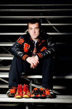 a man sitting on top of a bleachers bench