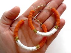 Get ready to cheer on the UT Vols this season with these cute orange and white hoop earrings! These 2-inch Tennessee earrings are nickel free, lightweight, and a Vols fan favorite. Materials: - 18k gold plated beads - 18k gold plated hoop earrings (2-inch in diameter) - Clay disc beads in orange and white Packaging: All UT earrings come packaged in a white jewelry box tied with a black and white gingham bow - ready to unwrap yourself or gift to your Tennessee-loving friend! Handmade in Chattanooga, TN by a UT alum - Go Vols! Looking for coordinating bracelets? See my UT Bracelet Stack here: https://www.etsy.com/listing/1319925113/tennessee-bracelet-ut-vols-bracelet ---- This listing is for 1 pair of Orange and White UT Hoop Earrings. Please don't hesitate to contact me with any questions! Adjustable Orange Hoop Earrings, Trendy Small Hoop Orange Jewelry, Trendy Small Hoop Orange Earrings, Orange Small Hoop Earrings With Ear Wire, Trendy Handmade Orange Hoop Earrings, Tennessee Earrings, Ut Vols, Heishi Jewelry, White Packaging