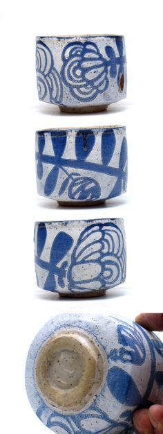 three blue and white bowls with designs on them, one being held by a person's hand