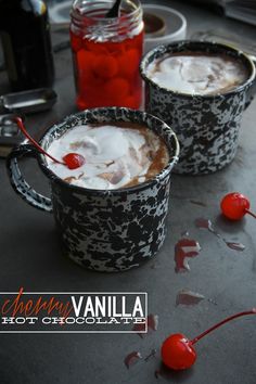 two mugs filled with hot chocolate and cherries