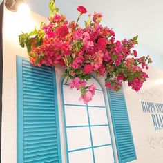 a window with blue shutters and pink flowers