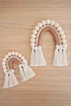 two wooden beads and tassels hang on a wall