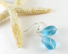 These light blue sea glass earrings are made with high-quality frosted glass that resembles ocean tumbled sea glass, but is much cheaper than ocean tumbled glass. Sea glass style jewelry is consistent in color, size, and shape, so the sea glass earrings you order will look just like the pair in the photos. I make these blue beach glass earrings in either silver plated or sterling silver materials. You can select the material you prefer from the drop-down menu. You can also select the ear wires y Blue Sea Glass Wire Wrapped Jewelry, Elegant Sea Glass Jewelry With Ear Wire, Elegant Jewelry With Sea Glass And Ear Wire, Elegant Blue Sea Glass Jewelry, Handmade Sea Glass Drop Earrings, Turquoise Wire Wrapped Sea Glass Jewelry, Sea Glass Dangle Earrings Jewelry Set, Turquoise Sea Glass Wire Wrapped Jewelry, Sea Glass Dangle Earrings With Matching Set