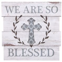 a wooden sign with the words we are so blessed written on it and a cross