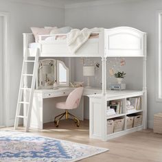 a white bunk bed sitting next to a desk with a mirror on top of it