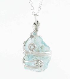 Nuggets of natural, watery-blue raw aquamarine crystals are hand-wrapped with swirls of elegant silver-plated wire to create these unique gemstone pendants. Material: Natural aquamarine & silver-plated wire Size: Varies, approximately 1-1/8" to 1-1/4" overall height (29-33 mm) Comes with a 20 inch long silver-plated chain (51 cm) 100 % Handmade Item number: wh365A Because these crystals are a natural product, each one is different and I am always careful to choose the prettiest side for the fron Unique Silver Aquamarine Jewelry, Silver Wire Wrapped Mineral Crystal Necklaces, Silver Wire Wrapped Jewelry With Mineral Crystal, Silver Hand Wrapped Mineral Crystal Necklaces, Silver Hand Wrapped Mineral Crystal Necklace, Silver Aquamarine Jewelry With Natural Stones, Light Blue Aquamarine Jewelry For Healing, Sterling Silver Jewelry With Blue Raw Stone, Blue Sterling Silver Jewelry With Raw Stone