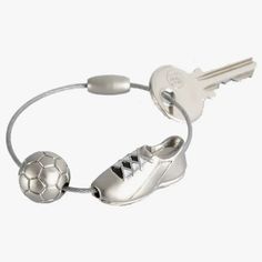 a silver bracelet with two soccer shoes and a key