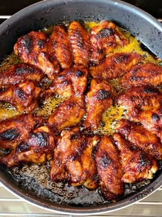 chicken wings cooking in a skillet on the stove