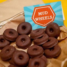 chocolate covered donuts sitting on top of a table next to a card that says mud wheels