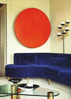 a living room filled with furniture and a large orange circle on the wall above it