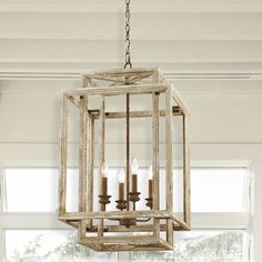 a chandelier hanging from the ceiling in a room with white walls and windows