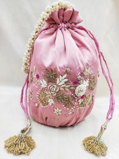 artisian handmade floral texture zardosi & thread embroidered solomon pink potli bag | wedding fabric handbag handmade with accessoryMaterial:SilkPackage Contents: As per quantity purchasedSize: 10” x 8”Designed with the heart, this beautiful Potli or batawa bag are eye catchy and made of premium material.Key Features:Embroidery art workThis potli is good match with both Indian and western outfits and are superb for wedding and festive partiesThis would be best complement to your designer sa Festive Pink Potli Bag For Party, Pink Shoulder Bag With Handwork For Party, Elegant Pink Shoulder Bag For Festivals, Pink Zari Work Potli Bag For Party, Pink Embroidered Fabric With Dori Work For Reception, Pink Handwork Pouch Bag, Elegant Pink Handmade Potli Bag, Pink Embroidered Pouch Clutch, Festive Pink Embroidered Shoulder Bag