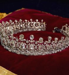 a tiara is displayed on a red velvet pillow