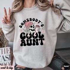 Get ready to be OBSESSED with your new 'Somebody's Cool Aunt' sweatshirt. It's the cutest and most trendy way to emit all those important Auntie vibes! This is the perfect Aunt sweatshirt! Great as an Auntie gift! * Q U I C K * F A C T S * ✺ 50/50 cotton polyester blend - so soft it feels like a cloud on your skin! ✺ Machine wash cold, inside out. Tumble dry low or hang to dry. Do not bleach, iron or dry clean. * S I Z I N G * ✺ Models are wearing XL for the oversized look ✺ Sizing is unisex so runs like men's, though not overly large ✺ Most women find their typical size works best for a more fitted look, since they are meant to fit a touch loose ✺ For the trendy oversized look, we recommend sizing up 1-2 sizes from your normal size ✺ Size guide and fit: See photos * P R O D U C T I O N * Long Sleeve Slogan Sweater For Winter, Cool Cotton Crew Neck Sweatshirt, Long Sleeve Winter Sweater With Slogan, Cool Crew Neck Tops For Winter, Cool Crew Neck Winter Sweatshirt, Cool Cotton Winter Tops, Cool Cotton Tops For Winter, Cool Sweatshirt With Letter Print, Fall Slogan Hoodie Top