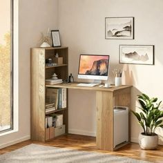 a desk with a computer on top of it in a room next to a window