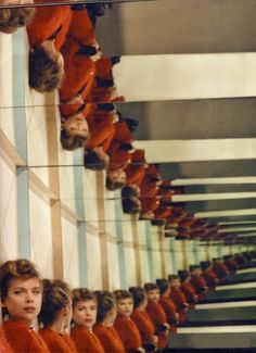 women in red dresses are lined up against the wall with their heads tilted to the side