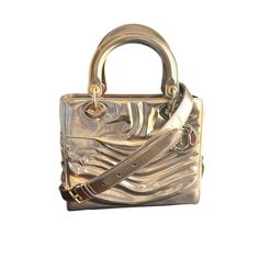 Description:  -Christian Dior Lady Art Bag  -Limited Edition by Jason Martin  -Gold and metallic patent leather  -Gold tone hardware   -Removable and adjustable shoulder strap  -Zip closure  -Protective feet at base  Authenticity: All items are guaranteed 100% authentic.  - Authenticity card included  -CD stamped zipper pull -Dior charms -Hardware stamped CD  Details:  Condition: SA2 EXCEPTIONAL (see condition rating below)Color: Gold**Color may vary by monitor or device. Please contact us for s Dior Lady Art Bag, Luxury Patent Leather Bags For Formal Occasions, Luxury Gold Shoulder Bag With Palladium Hardware, Elegant Patent Leather Evening Bags, Luxury Silver Shoulder Bag With Gold-tone Hardware, Luxury Bags With Glossy Finish For Formal Occasions, Designer Formal Bags With Glossy Finish, Designer Glossy Finish Bags For Formal Occasions, Luxury Glossy Formal Bags