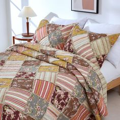 a bed with a quilted comforter and pillows