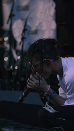 a man with dreadlocks sitting on the ground