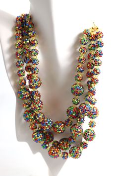 Capture the magic of rainbows with this dazzling necklace! Three strands of colorful rhinestone balls and a touch of yellow crystal make this piece perfect for any occasion. The adjustable chain and large lobster claw clasp let you customize the fit, while the dazzling display of colors will leave everyone in awe. Whether you're going out on the town or just running errands, these Rainbow Balls will help you brighten up your day! Party Round Beads Ball Chain Necklaces, Party Round Beads Ball Chain Necklace, Party Ball Chain Necklaces With Round Beads, Party Necklace With Round Beads And Ball Chain, Rainbow Crystal Jewelry With Rhinestones, Multicolor Rhinestone Necklace With Sparkling Stones For Party, Party Multicolor Bling Jewelry, Multicolor Crystal Necklace With Rhinestones, Multicolor Rhinestone Necklace For Party