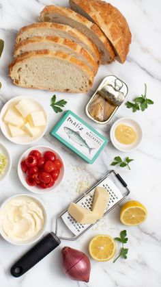 bread, cheese and other ingredients are arranged on a marble surface