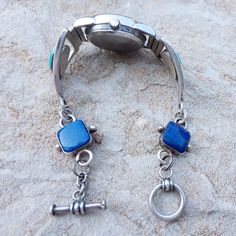 "This is a stunning watch bracelet combination made with lapis and turquoise with a Lapis time piece. The bracelet link watch is made with Sterling silver and has a smooth polished finish, the ends of the watch links connect with a toggle clasp. The watch bracelet was made by Juan Abeyta I assumed he made more than one of these back around 25 years ago but I haven't seen another one if he did. We've replaced the battery in the watch and the Lapis time piece keeps perfect time. The Lapis is royal Blue Jewelry With Stainless Steel Clasp For Gift, Blue Stainless Steel Jewelry With Round Dial, Blue Stainless Steel Round Dial Jewelry, Watch Bracelet, Stone Inlay, Vintage Navajo, Toggle Clasp, Handmade Artisan, Turquoise Sterling Silver