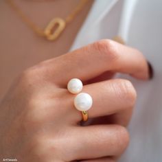 This elegant ring features two lustrous freshwater pearls, designed in a beautiful Tui et Moi style. Crafted from 925 sterling silver, the open ring design offers a modern and sophisticated look. Perfect as a statement piece, this ring makes a lovely gift for her. Add a touch of timeless elegance to any outfit with this exquisite freshwater pearls ring. DETAILED DESCRIPTION// Material: 925 sterling silver Finish: 18k gold Stone: Freshwater pearls  Pearls size: 8mm /10mm Adjustable size, which ca Open Ring Pearl Charm For Anniversary, Pearl White Rings With Pearl Charm For Anniversary, Open Pearl Ring With Pearl Drop, Anniversary Pearl White Rings With Pearl Charm, Anniversary Rings In Pearl White With Pearl Charm, Open Ring With Pearl Drop, Pearl White Open Ring For Anniversary, White Pearl Open Ring, Anniversary Akoya Pearl Rings