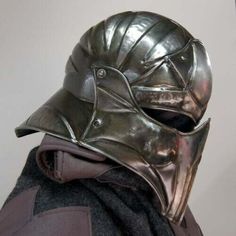 a close up of a person wearing a metal helmet