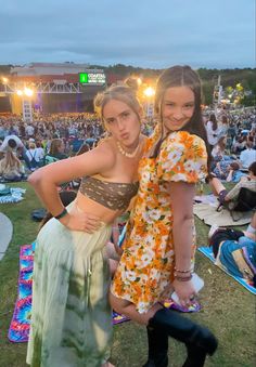 two women standing next to each other in front of an audience at a music festival