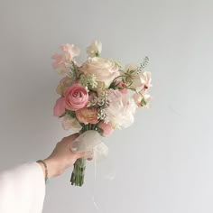 a person holding a bouquet of flowers in their hand