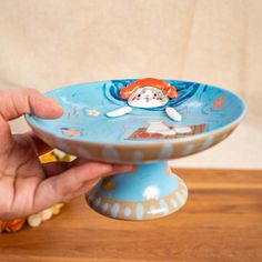 🐱 "Floating Picnic Kitty" - Handcrafted Ceramic Stand & Jewelry Dish 🐱 Let your imagination drift into a delightful world with our "Floating Picnic Kitty"! This playful ceramic stand features an adorable kitty floating in a serene pool, surrounded by whimsical flowers and a charming little picnic scene. With its versatile design, this ceramic stand can be used as a jewelry holder, a decorative tray, or even an elegant serving dish for small treats--adding a touch of whimsy to any space. 🎨 Uni Ceramic Stand, Picnic Scene, Cat Trinket, Whimsical Flowers, Small Treats, Stand Jewelry, Trinket Holder, Eco Friendly Paint, Grey Cat