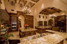 a large kitchen with marble counter tops and an archway leading to the dining room area