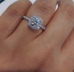 a woman's hand with a diamond ring on top of her finger and an engagement band