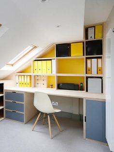 an attic office with yellow and blue cabinets