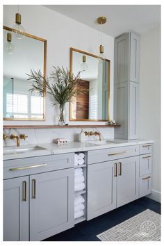 a bathroom with two sinks, mirrors and towels on the counter top next to each other