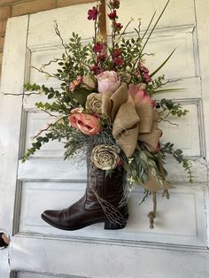 a cowboy boot with flowers in it sitting on the side of a white door frame