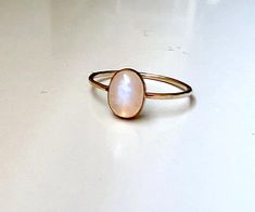 A glowing 8x6mm rainbow moonstone is set in a smooth 14k gold-filled bezel on a dainty slightly hammered band. Perfect for stacking alongside a band! Delicate Oval Moonstone Ring In 14k Gold, Hand Forged Gold Oval Moonstone Ring, Everyday Oval Moonstone Ring, Hand Forged Oval Moonstone Ring, Dainty Rose Gold Moonstone Ring, Delicate 14k Gold Stackable Moonstone Ring, Minimalist Oval Moonstone Ring For Everyday, Minimalist 14k Gold Moonstone Ring With Bezel Setting, Handmade 14k Gold Oval Moonstone Ring